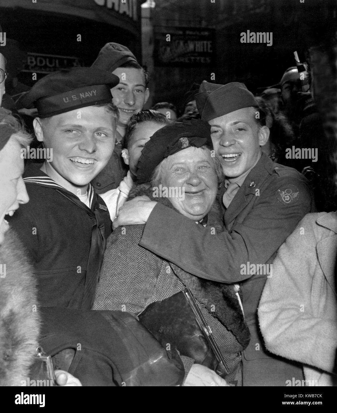 V-e giorno in festa a Piccadilly Circus, Londra, 7 maggio 1945. Un esultante soldato americano abbracci di materna donna inglese celebra la Germania la resa incondizionata. Guerra mondiale 2. (BSLOC_2014_8_105) Foto Stock