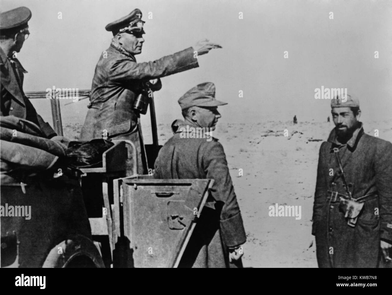 Generale Rommel in piedi in jeep nel nord deserto africano, Feb. 1-10, 1942. Guerra mondiale 2. Rommel italo-tedesca forze erano riforniti con i serbatoi carburante e nel gennaio 1942. Egli ha ben presto catturato Bengasi, Libia. Egli ha sconfitto il britannico a Tobruk il 21 giugno 1942. (BSLOC 2014 8 159) Foto Stock Generale Rommel in piedi in jeep nel nord deserto africano, Feb. 1-10, 1942. Guerra mondiale 2. Rommel italo-tedesca forze erano riforniti con i serbatoi carburante e nel gennaio 1942. Egli ha ben presto catturato Bengasi, Libia. Egli ha sconfitto il britannico a Tobruk il 21 giugno 1942. (BSLOC 2014 8 159) Foto Stock