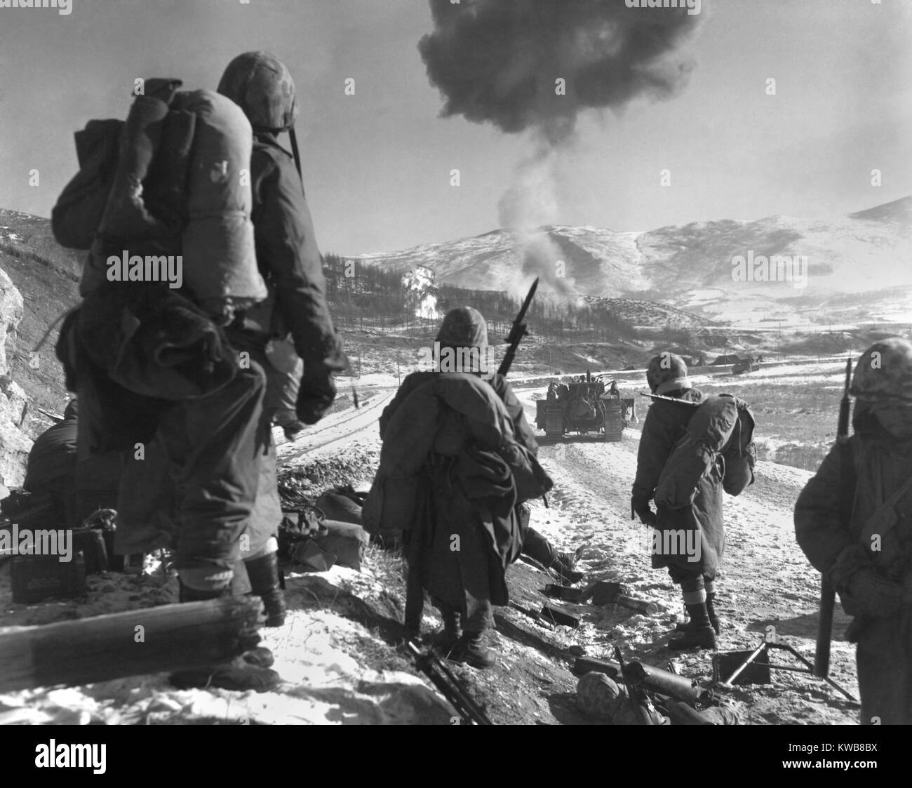 Stati Uniti Marines in pausa la diga in modo da Hagaru a Kotori nel ritiro dal serbatoio di Chosin. Marine corsari napalm abbandonati U.S. Esercito camp tenda che era diventata una calamita per le truppe Cinesi in cerca di cibo e riparo. Ca. Dec. 3-8, 1950. Guerra di Corea, 1950-1953. (BSLOC 2014 11 100) Foto Stock