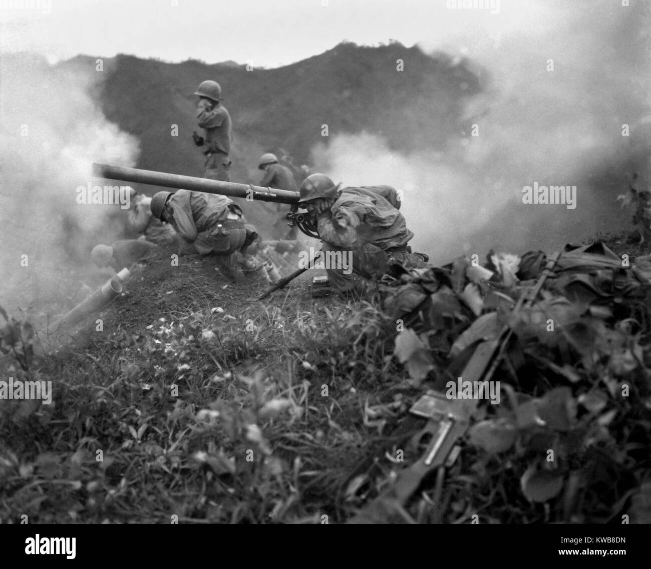 Stati Uniti Esercito gunner (accovacciato in primo piano), incendi un 75mm recoilless rifle. Essi stanno combattendo vicino Oetlook-tong, Corea, a sostegno delle unità di fanteria direttamente attraverso la valle. Giugno 9, 1951. Entro la fine di giugno le linee di battaglia vicino al 38° parallelo sarebbe cambiato poco nei restanti 2 anni della guerra di Corea. (BSLOC 2014 11 112) Foto Stock