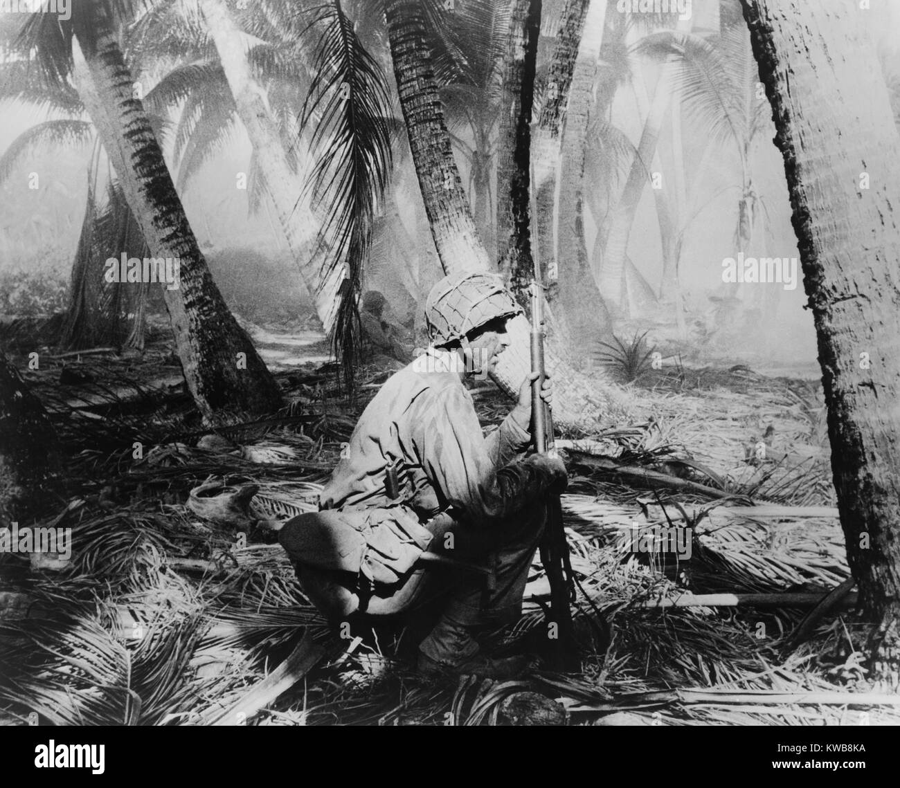 Stati Uniti Soldati crouch sulle fronde di palma come essi spingono avanti su Makin Atoll nelle isole Gilbert. Nov. 20-23, 1943. La massa degli Stati Uniti di feriti sono stati 66 morti e 152 feriti contro 395 giapponesi uccisi e 3 acquisiti. Guerra mondiale 2. (BSLOC 2014 10 101) Foto Stock