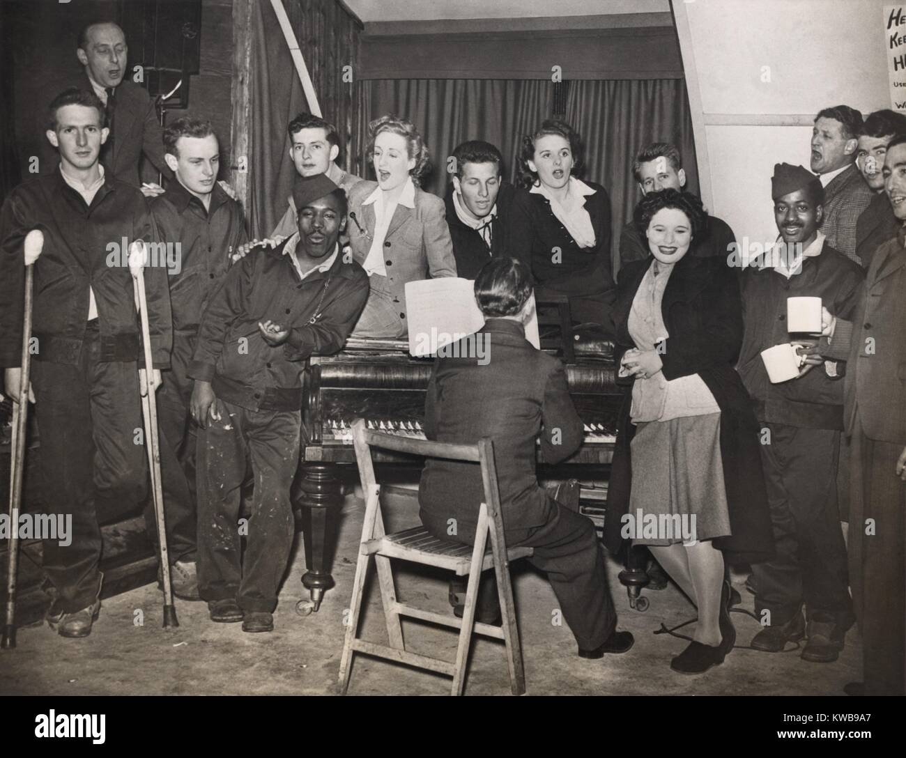 American GIs sono intrattenuti dal pianista Horatio Davies, presso un ospedale militare a ovest dell'Inghilterra. Sia il nero e il bianco i soldati sono inclusi nel British ENSA (Intrattenimenti Servizio Nazionale Associazione songfest). 1944. Guerra mondiale 2. (BSLOC 2014 10 236) Foto Stock