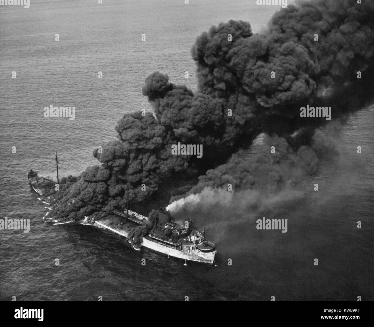 Un silurato American tanker combustione dopo un asse di attacco sottomarino. I membri dell'equipaggio ha portato il fuoco sotto il controllo e la nave è stata rimorchiata al porto per la riparazione. Ca. 1942-43. Guerra mondiale 2. (BSLOC 2014 10 66) Foto Stock