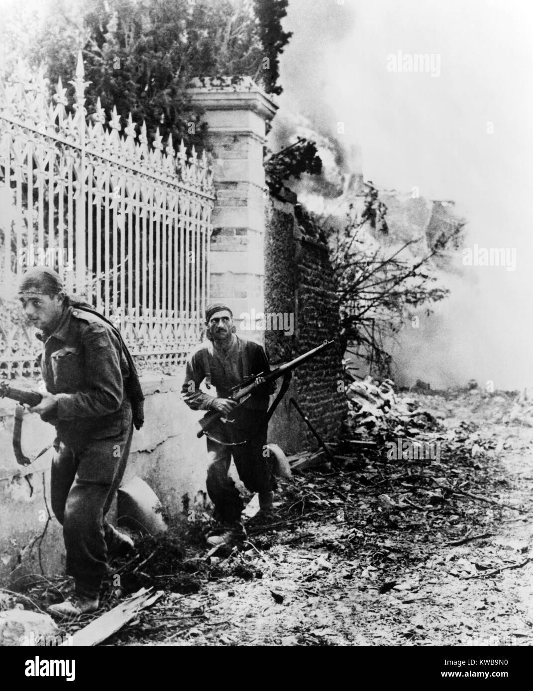 Due soldati canadesi bordo lungo la parete, sull'avviso per il tedesco cecchini, vicino a Falaise, Francia. Ca. Agosto 6-21, 1944. La Normandia, guerra mondiale 2. (BSLOC 2014 10 80) Foto Stock