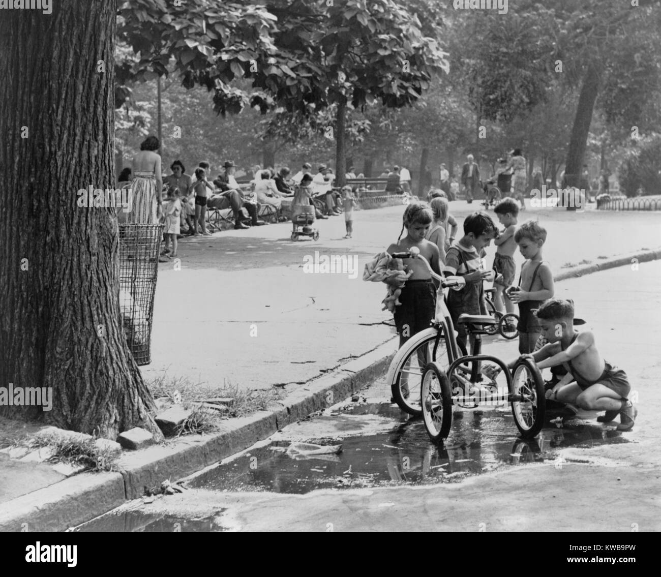 I bambini con i tricicli giocare nei pressi di una pozza in Washington Square Park. New York City il Agosto 3, 1948. (BSLOC_2014_13_167) Foto Stock