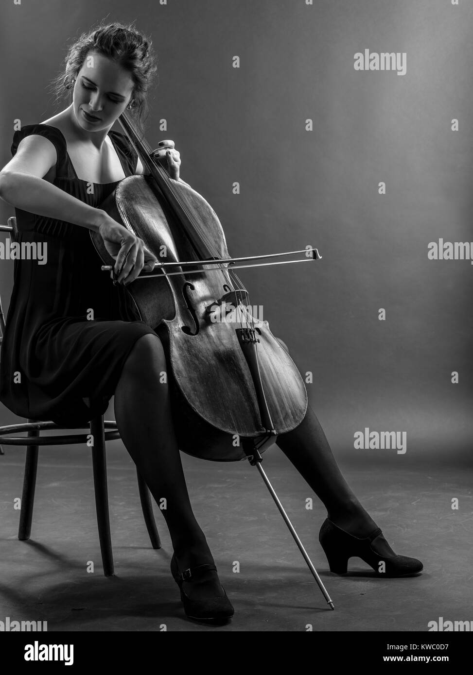 Foto di una bellissima femmina musicista giocando un violoncello. Immagine in bianco e nero. Foto Stock