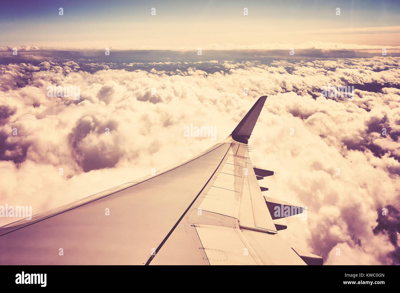 Un piano ala sopra le nuvole visibili attraverso una finestra di un aeromobile, colore nei toni del concetto di viaggio foto. Foto Stock