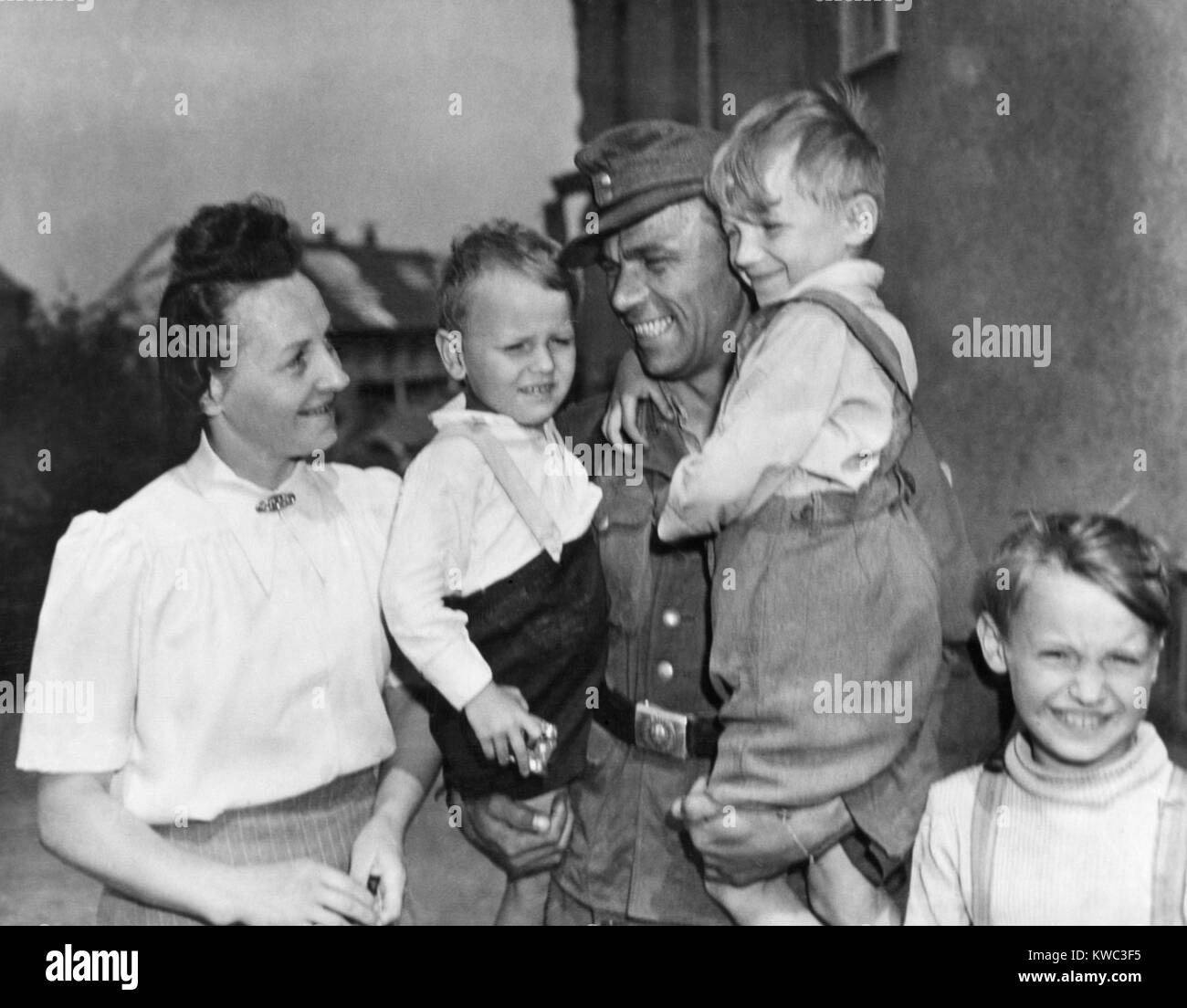 Scaricate soldato tedesco Fritz Reidel tornò a sua moglie e i suoi due figli, 21 maggio 1945. I militari USA ha iniziato a scaricare i soldati tedeschi dopo gli esami medici e le impronte digitali. Essi sono stati forniti 40 marchi, documenti di scarico e trasporto alle loro case. Reidel, è stato il primo prigioniero di guerra per essere rilasciato dal POW Camp a Plauen, Germania. Guerra Mondiale 2 (BSLOC 2015 13 78) Foto Stock