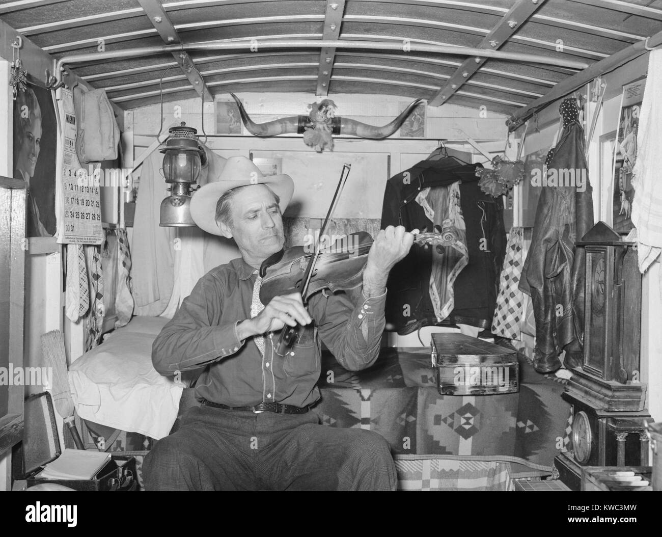 Il sig. Bias suonare il violino nella sua casa di rimorchio. Egli è un ex cowboy che percorre la vita di campagna su un piccolo reddito privato. Weslaco, Texas. Febbraio 1930 (BSLOC 2015 14 145) Foto Stock Il sig. Bias suonare il violino nella sua casa di rimorchio. Egli è un ex cowboy che percorre la vita di campagna su un piccolo reddito privato. Weslaco, Texas. Febbraio 1930 (BSLOC 2015 14 145) Foto Stock