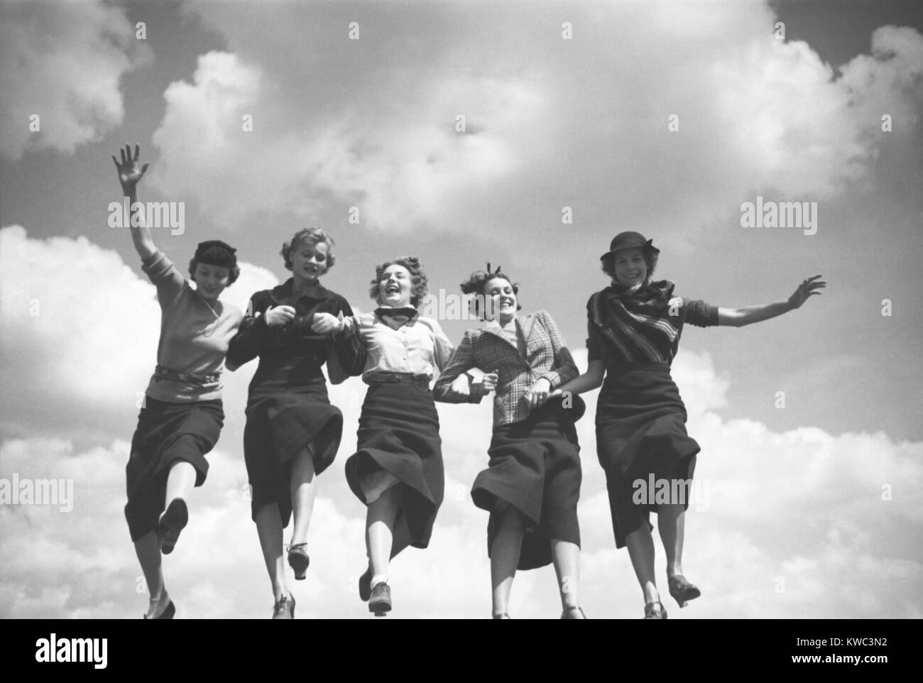 Cinque modelli di moda tenendo le mani e piedi in una riga con il cielo come sfondo. Agosto 1935, dai toni Frissell. (BSLOC 2015 14 146) Foto Stock