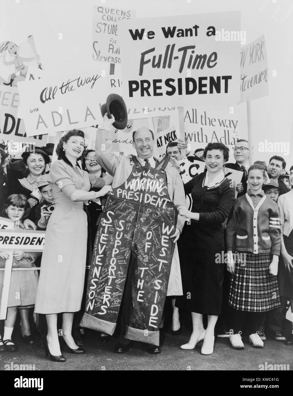 E. Adlai Stevenson è stato presentato con firma-decorate blu denim tuta da sostenitori. Un grande segno legge "Vogliamo un Full-Time Presidente." Il Presidente uscente Eisenhower ha lavorato per mesi per recuperare da un attacco di cuore nel 1955. Dall'Aeroporto La Guardia di New York City (BSLOC 2015 14 30) Foto Stock