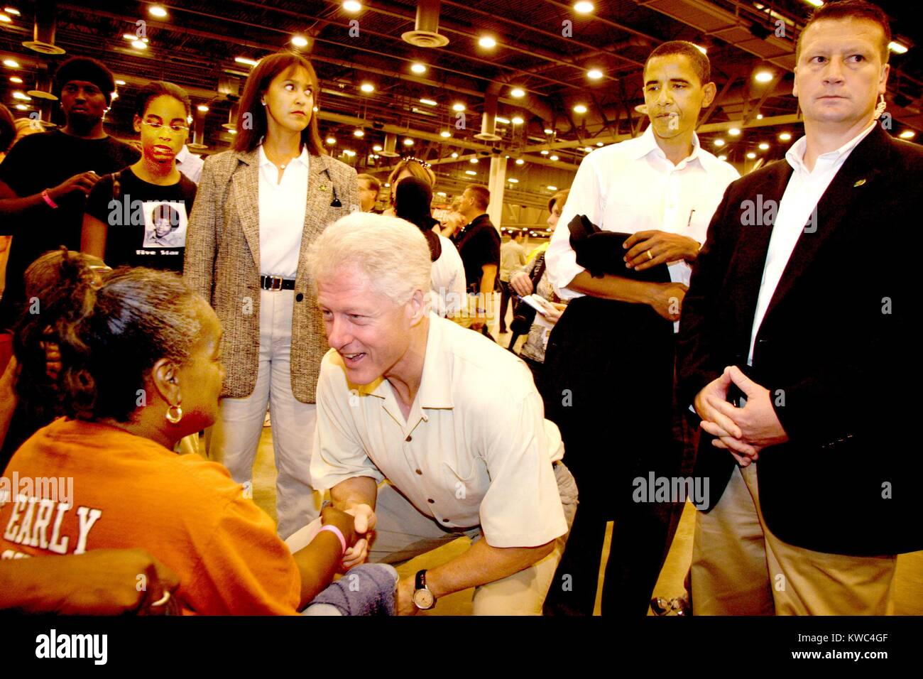 Il presidente Bill Clinton saluta un Katrina evacuee a Houston Astrodome. Settembre 5, 2005. Lui e il Presidente George H.W. Bussola (bussola 41) erano a Astrodome per annunciare un nuovo Relief Fund. In background mantenendo il Clinton jacket è il senatore Barack Obama. (BSLOC 2015 2 207) Foto Stock