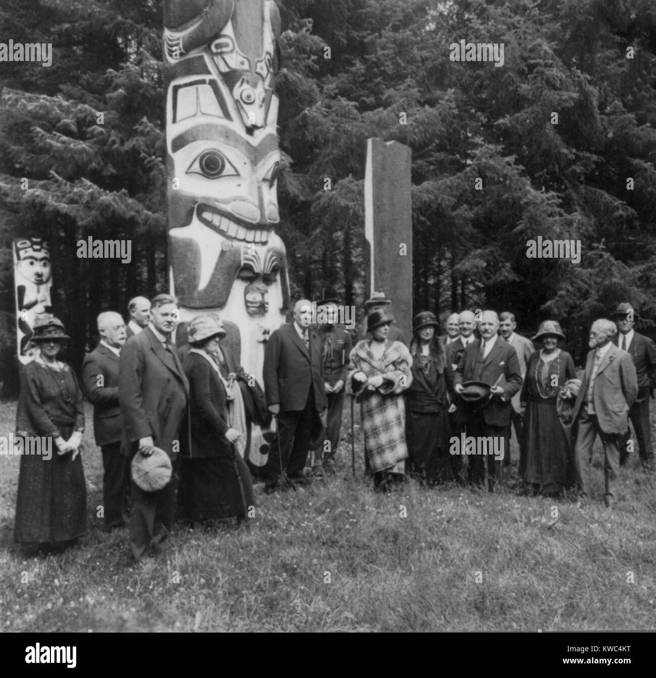 Il presidente Warren Harding e la sua Alaska party presso il grande Alaskan Totem Pole a Sitka. Luglio 1923. La First Lady Firenze Harding indossa un bold plaid coat. Herbert Hoover è quarta da sinistra. (BSLOC 2015 15 79) Foto Stock