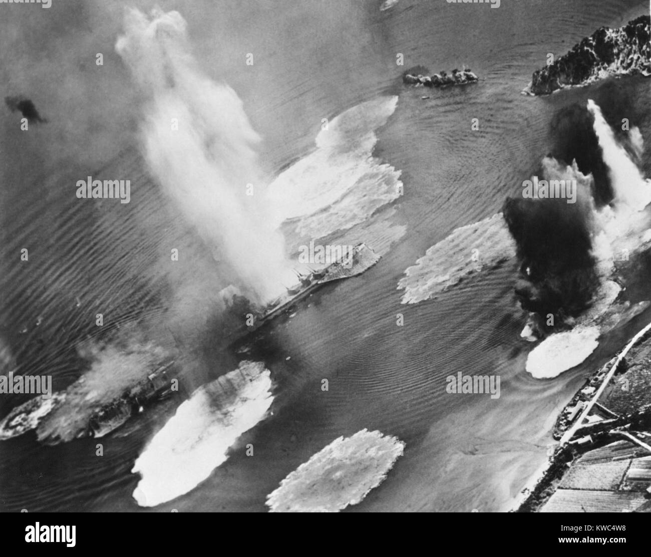 Negli Stati Uniti i piani del gestore bomba incrociatori giapponesi ancorato nel porto di Kure Base Navale a Honshu. La nave da guerra sotto attacco è quasi completamente nascosta dai geyser di acqua da near misses. Luglio 1945. Guerra Mondiale 2 (BSLOC 2015 13 122) Foto Stock