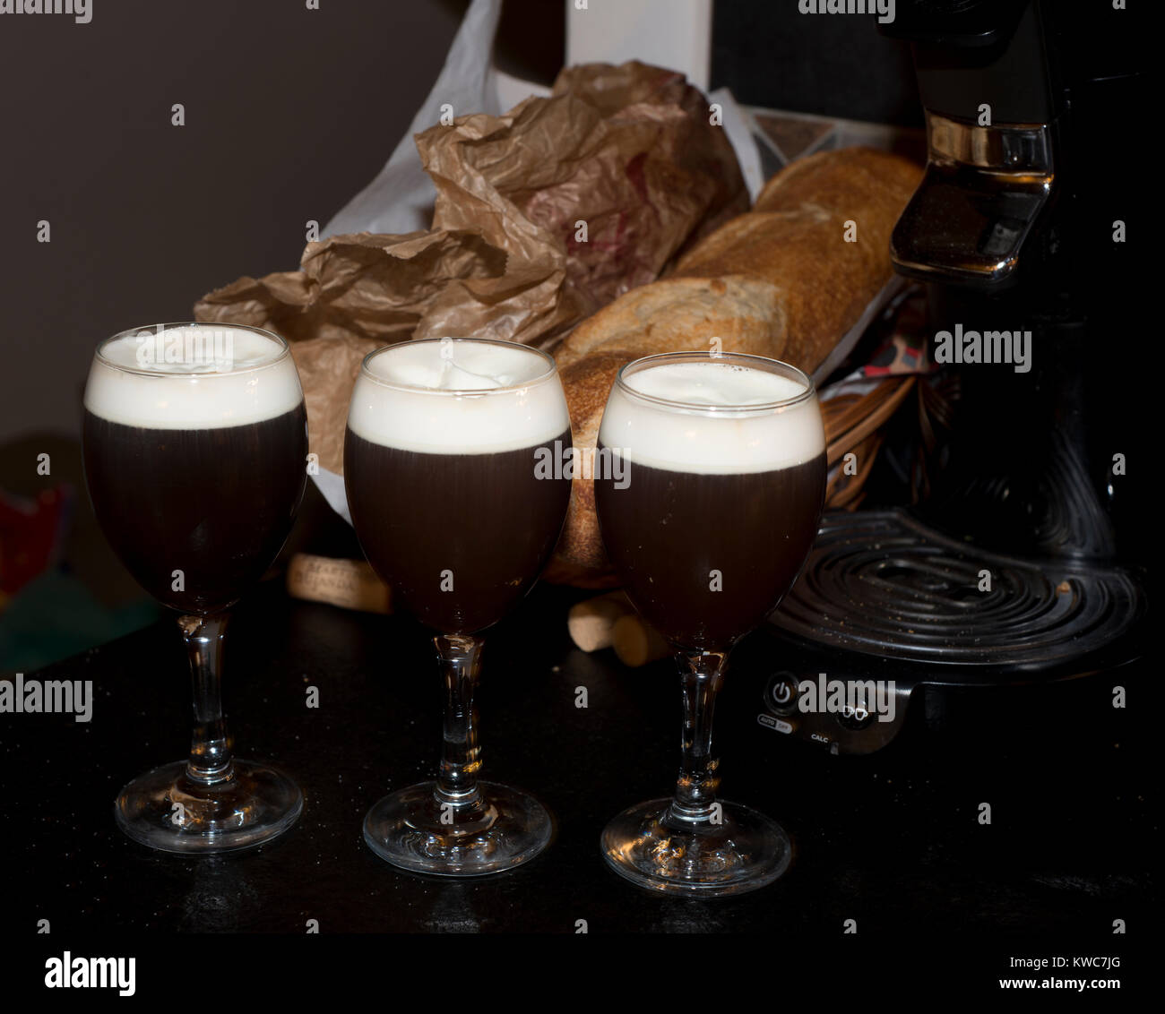 Tre caffè irlandese in 3 bicchieri da caffè irlandese con due baguette sullo sfondo Foto Stock