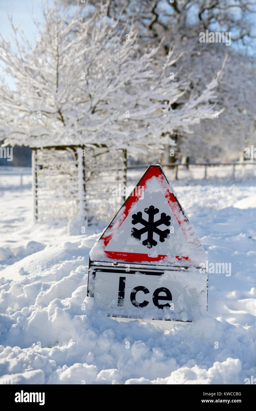 Un avvertimento di ghiaccio segno coperto di neve. Foto Stock