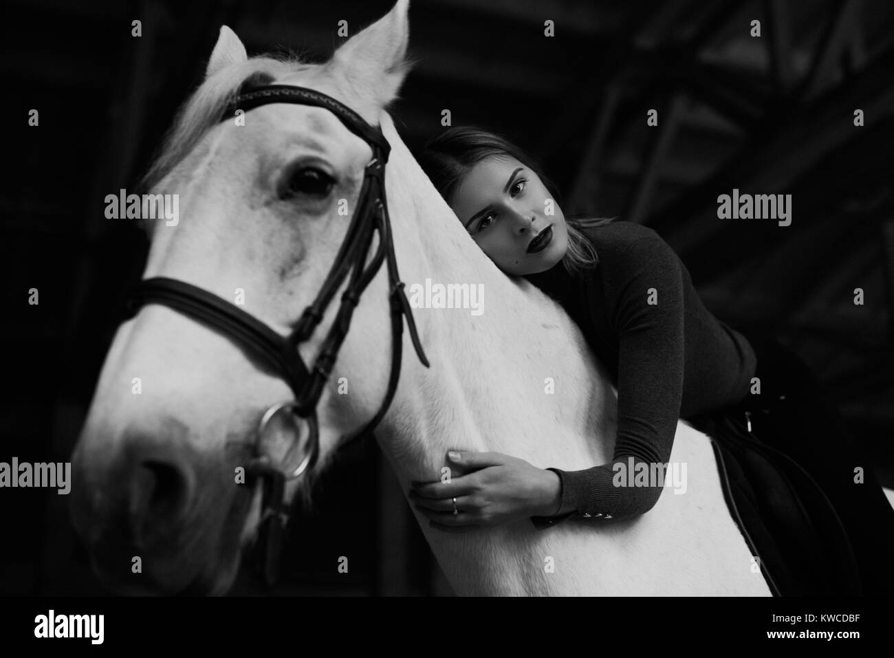 Guarda dal basso in gara donna sdraiata sul cavallo bianco. Foto Stock