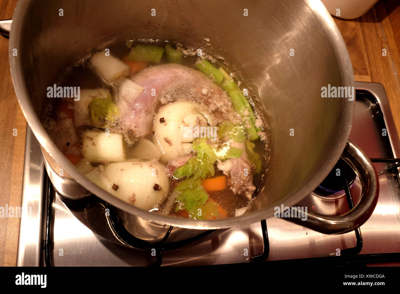 La Turchia un brodo fatto con le frattaglie e verdure compresi cipolla carota e sedano simmering sul piano cottura in pentola Foto Stock
