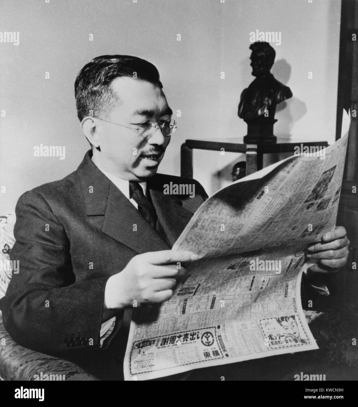 L'imperatore Hirohito felicemente legge circa la firma di un trattato di pace tra gli Stati Uniti e il Giappone. Il trattato ha segnato la fine della U.S. Occupazione del Giappone. In fondo è una statua del presidente americano, Abramo Lincoln. 1952. - (BSLOC_2014_15_139) Foto Stock