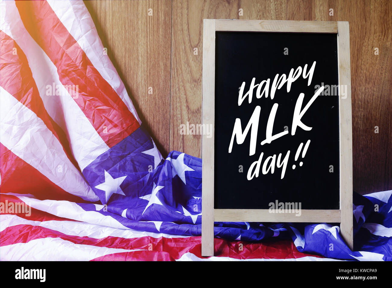 Happy MLK Day Tipografia sulla lavagna e bandiera degli Stati Uniti scena. Illustrazione della foto Foto Stock