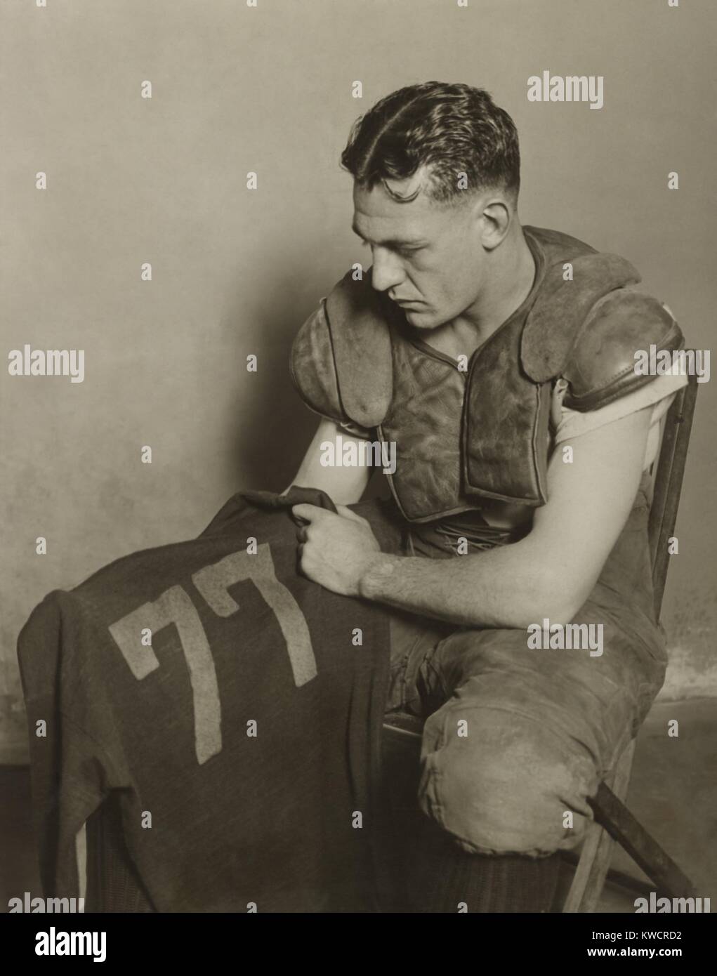 Harold 'Rosso' Grange tenendo il suo calcio jersey numero. Il suo numero 77 è stato ritirato presso la University of Illinois nel 1925. - (BSLOC 2015 1 112) Foto Stock