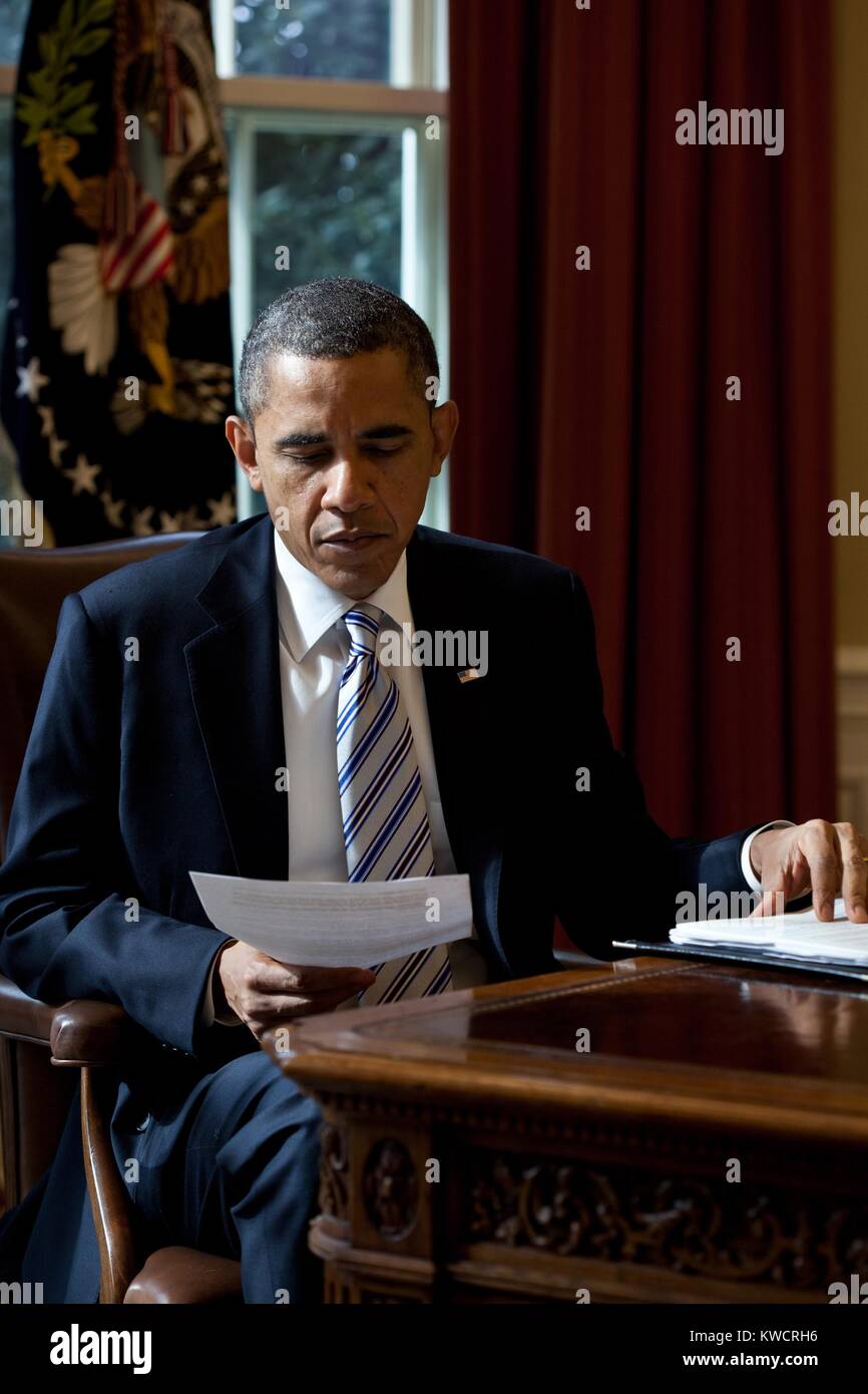 Il presidente Barack Obama legge un documento nell'Ufficio Ovale, Feb 21, 2012. (BSLOC_2015_3_3) Foto Stock