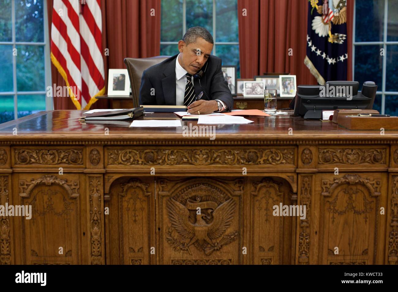 Il presidente Barack Obama al suo ufficio ovale scrivania, Sett. 7, 2011. Obama sta parlando con Gov. Rick Perry circa l inaudita incendi in Texas. (BSLOC 2015 3 2) Foto Stock