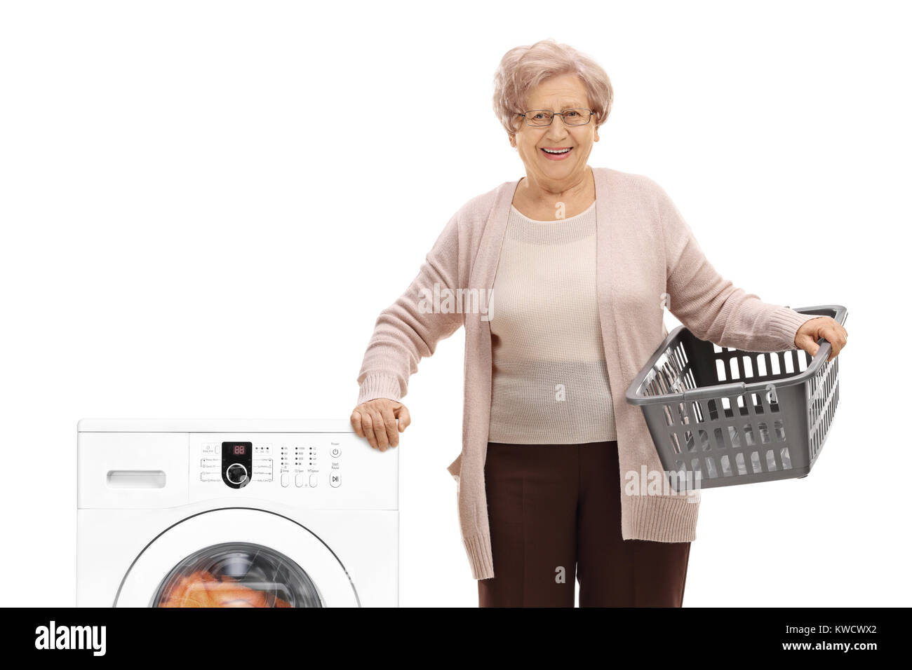 Donna anziana con un vuoto di un cesto della biancheria accanto ad una macchina di lavaggio isolata su sfondo bianco Foto Stock