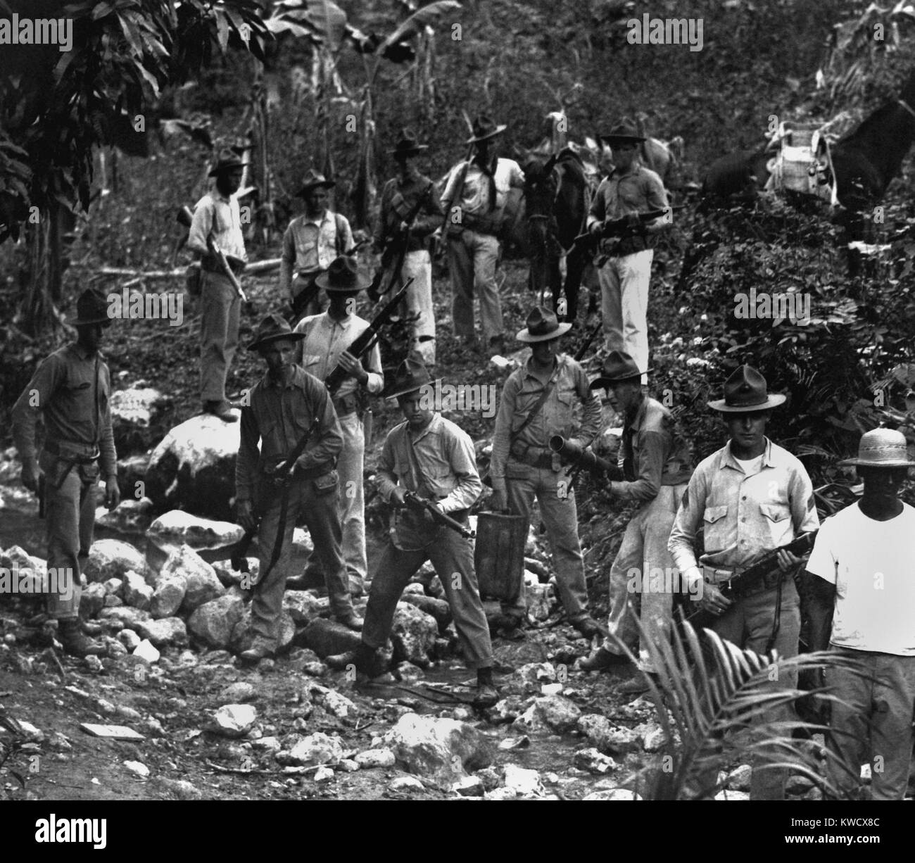 Marines americani e una guida alla ricerca di banditi nel 1919 durante l'occupazione statunitense di Haiti. Occupazione statunitense appoggiato la segregazione razziale, premere la censura, la corruzione economica e del lavoro forzato che ha portato a un contadino ribellione nel 1919-20 (BSLOC 2017 2 79) Foto Stock