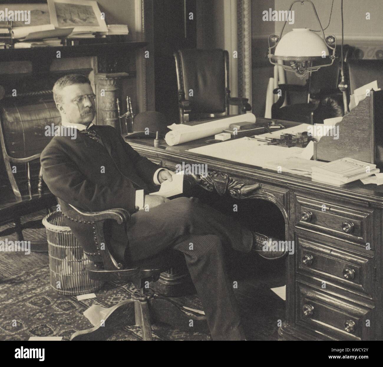 Assistente del segretario della Marina, Theodore Roosevelt alla sua scrivania, 1897-98. Sul pavimento vengono scartati i documenti appaiono in altro ufficio ritratti di TR (BSLOC 2017 4 99) Foto Stock