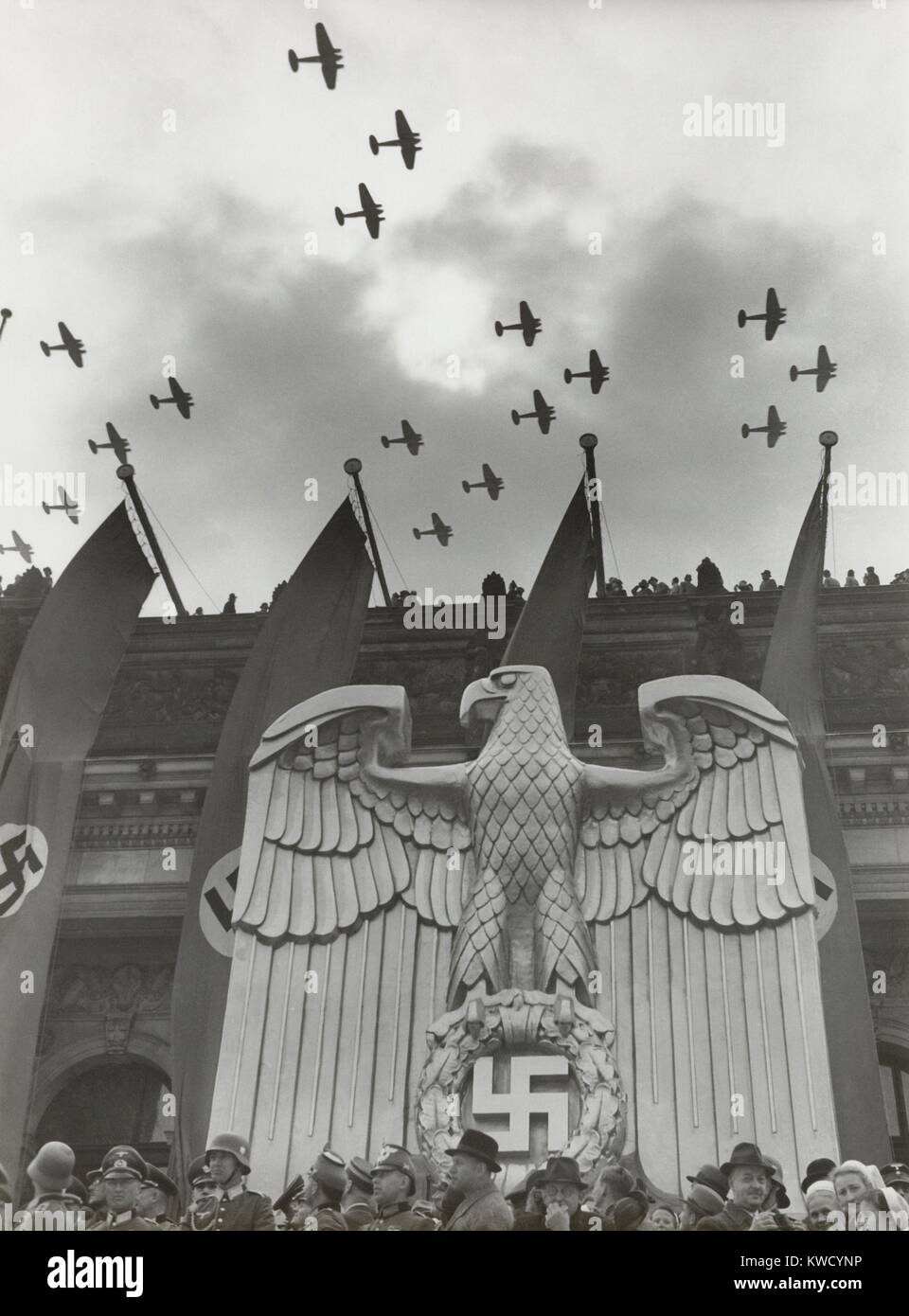 Luftwaffe Fly-By in onore del compleanno di Hitlers nel quartiere di Charlottenburg, Berlino, 20 aprile 1939. Per l'edificio è una scultura di un nazista tedesco eagle e striscioni con svastiche (BSLOC 2017 2 70) Foto Stock