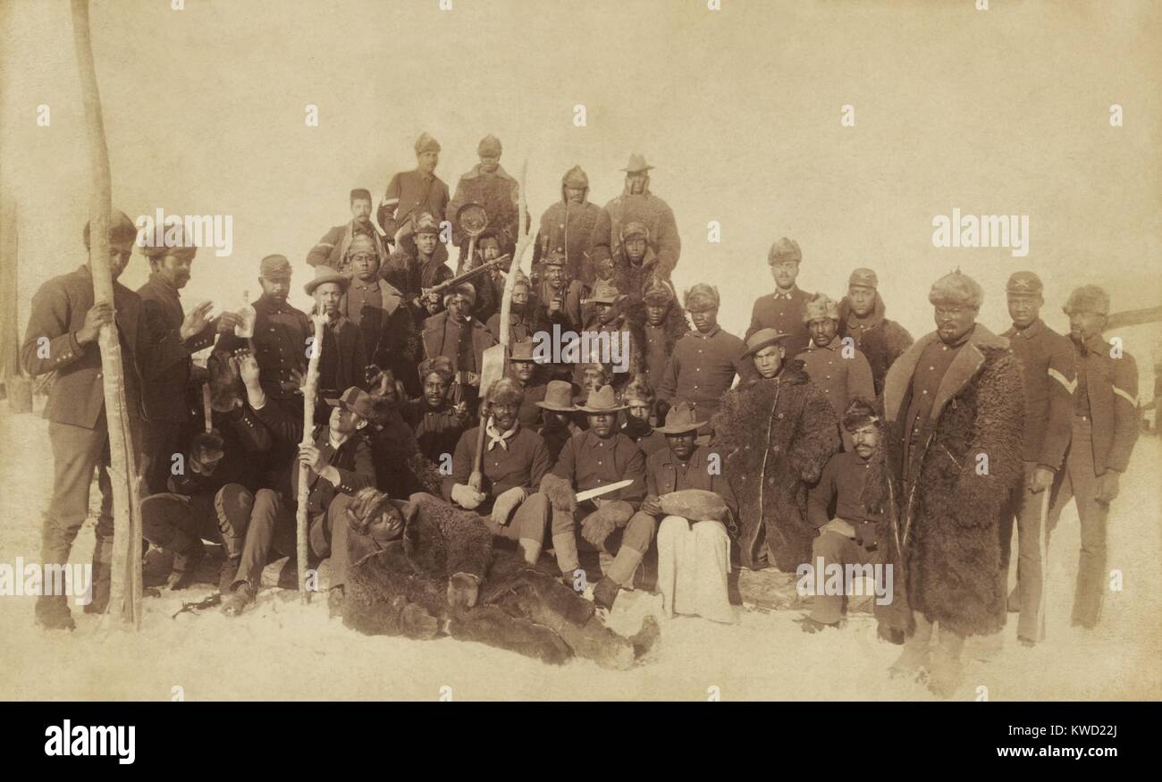Buffalo soldati della fanteria XXV, diversi indossare vesti di Buffalo, Ft. Keogh, Montana, 1890. A sinistra due uomini raggiungono per una bottiglia di essere passata mentre si pone in questo rilassato gruppo verticale (BSLOC 2017 20 104) Foto Stock