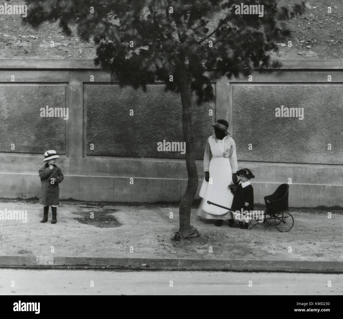 African American servo avendo cura di due giovani bambini Bianco a Washington, D.C., 1910. La posizione è Meridian Hill Park, tra il XV e il XVI strade, NW, in Columbia Heights quartiere (BSLOC 2017 20 109) Foto Stock