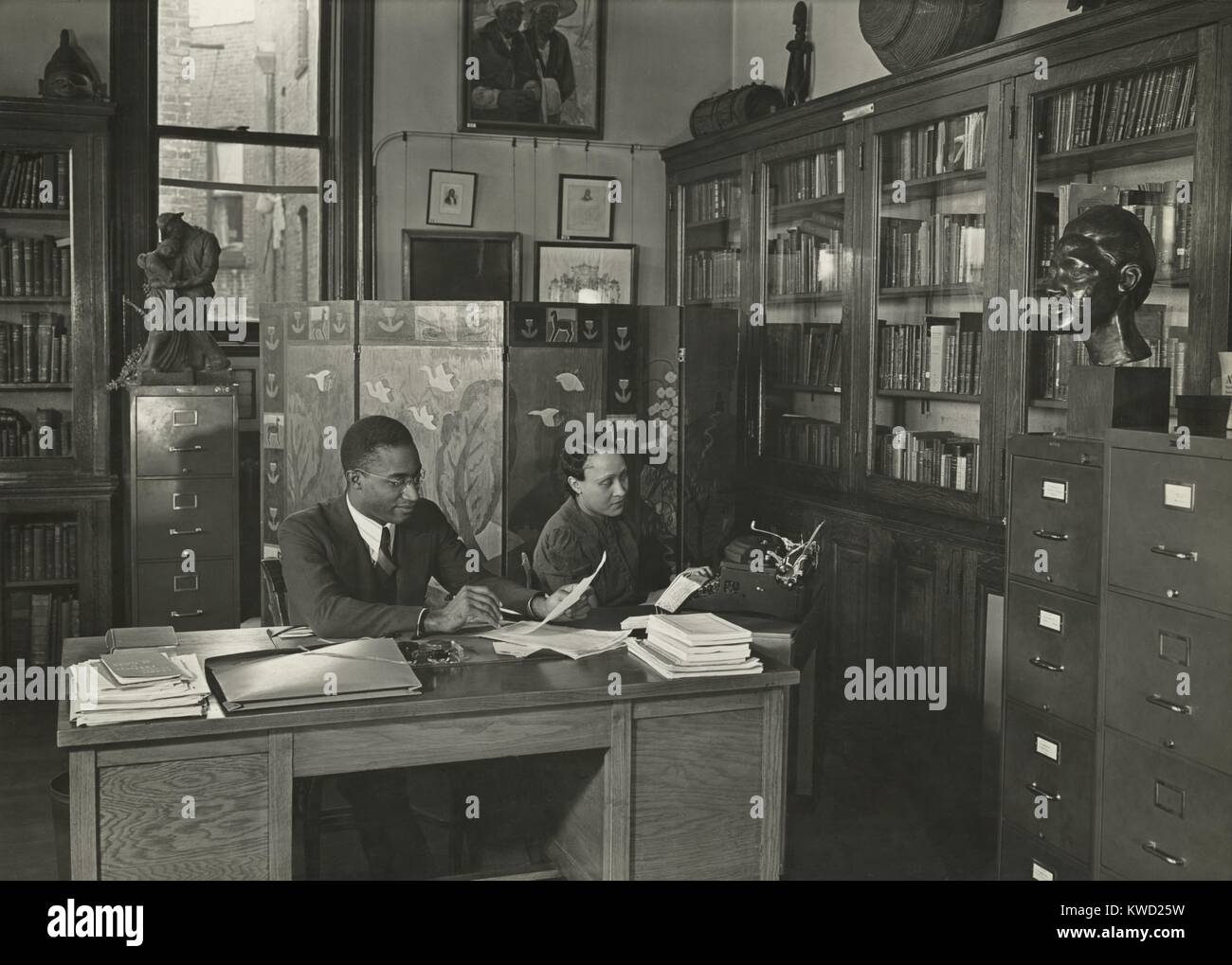 Il dottor Lawrence D. Reddick, è stato curatore della collezione Schomburg, New York Public Library, 1939-48. Mostra fotografica di lui fra le opere d'arte e libri raccolti da Arturo Alfonso Schomburg (BSLOC 2017 20 166) Foto Stock