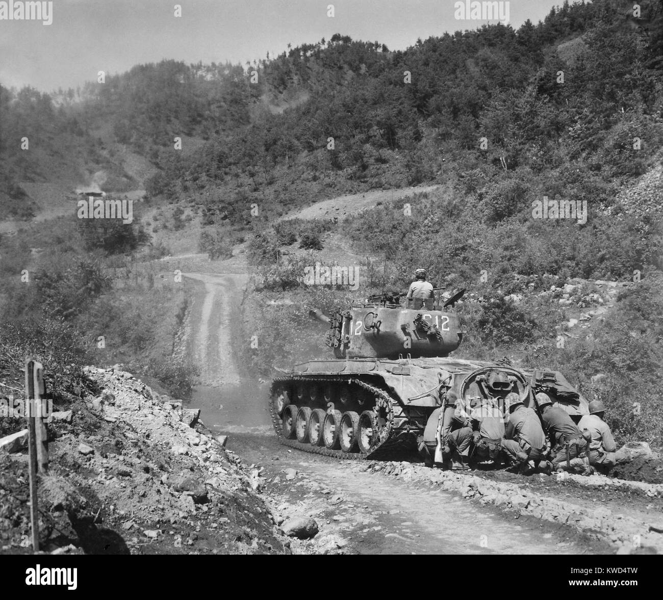 Stati Uniti Marine di fanti prendere la copertura dietro un serbatoio mentre incendi sulle truppe comuniste in anticipo. Area Hongchon, Corea centrale, 22 maggio 1951. Guerra di Corea, 1950-1953. (BSLOC 2014 11 110) Foto Stock