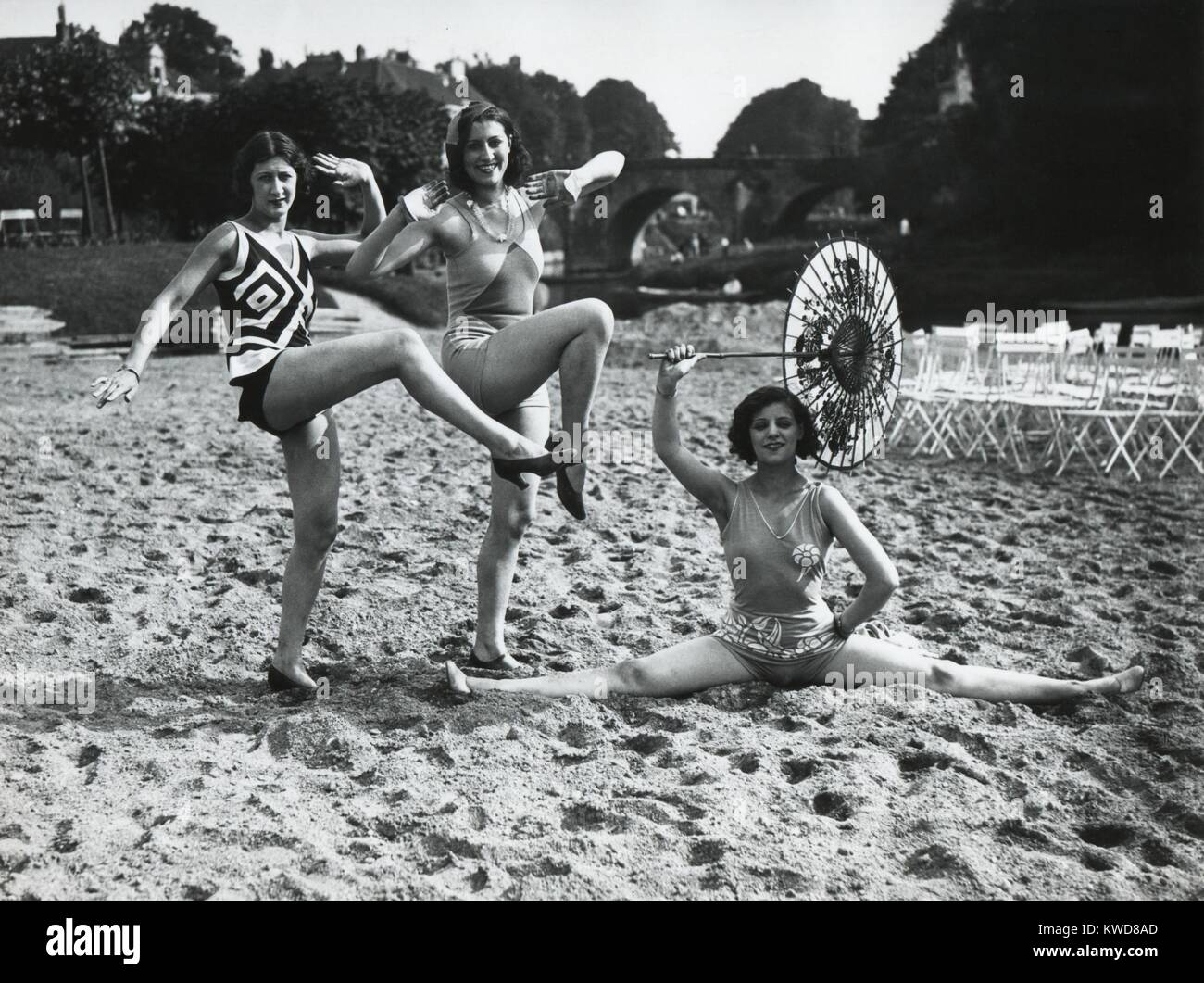 Acrobatico donne francesi pongono nell'ultima moda costumi da bagno sulla spiaggia di sabbia a Dieppe. Ca. 1925. (BSLOC 2015 17 202) Foto Stock