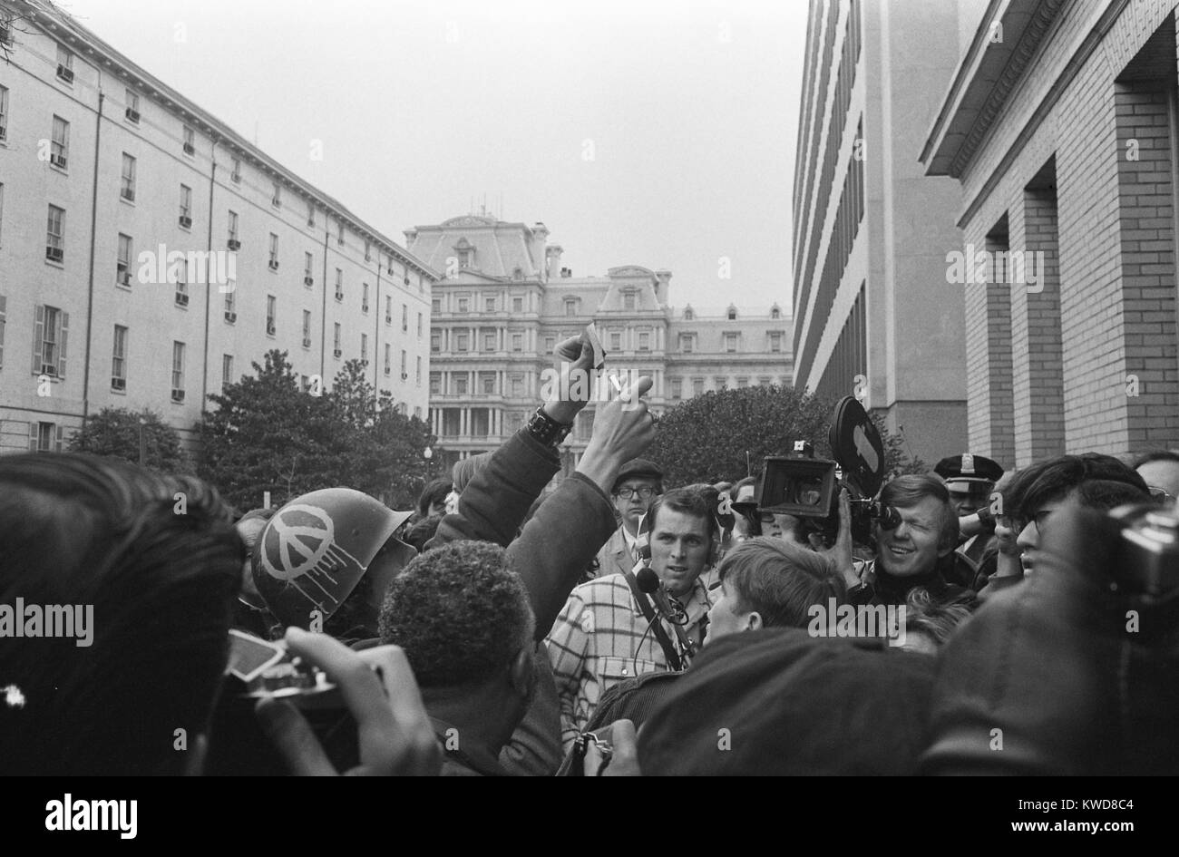 Giovane uomo americano che indossa un casco con un segno di pace bruciando il suo progetto di carta, Marzo 19, 1970. Egli è stato la dimostrazione contro la guerra del Vietnam presso il servizio selettivo quartier generale del sistema. Washington, D.C. (BSLOC 2015 17 233) Foto Stock