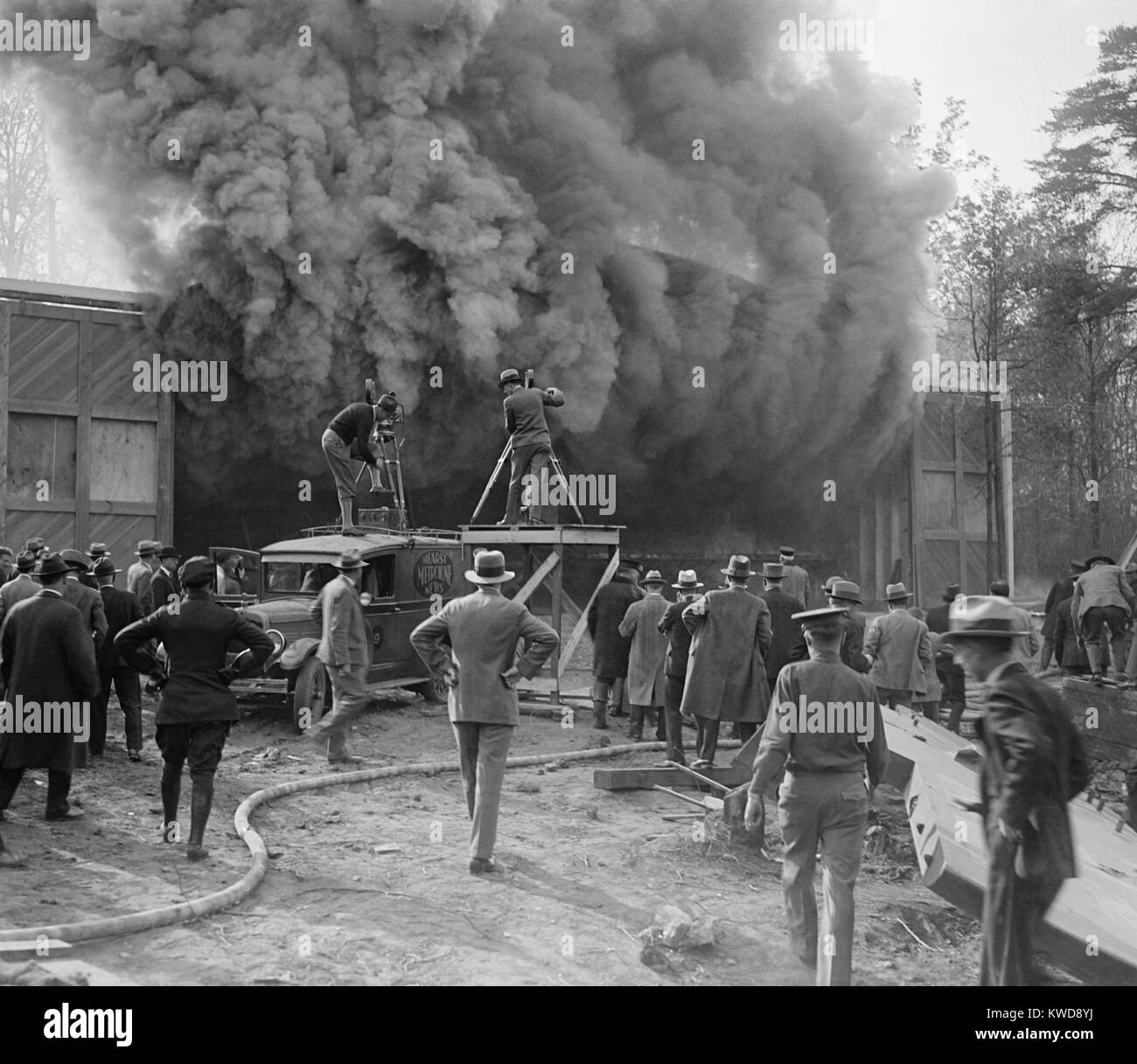Hearst Movietone cameraman di film di un incendio in Washington, D.C. in c. 1920. Un uomo si erge sul tetto del suo carrello come fumi densi riversa da un edificio (BSLOC 2016 8 156) Foto Stock