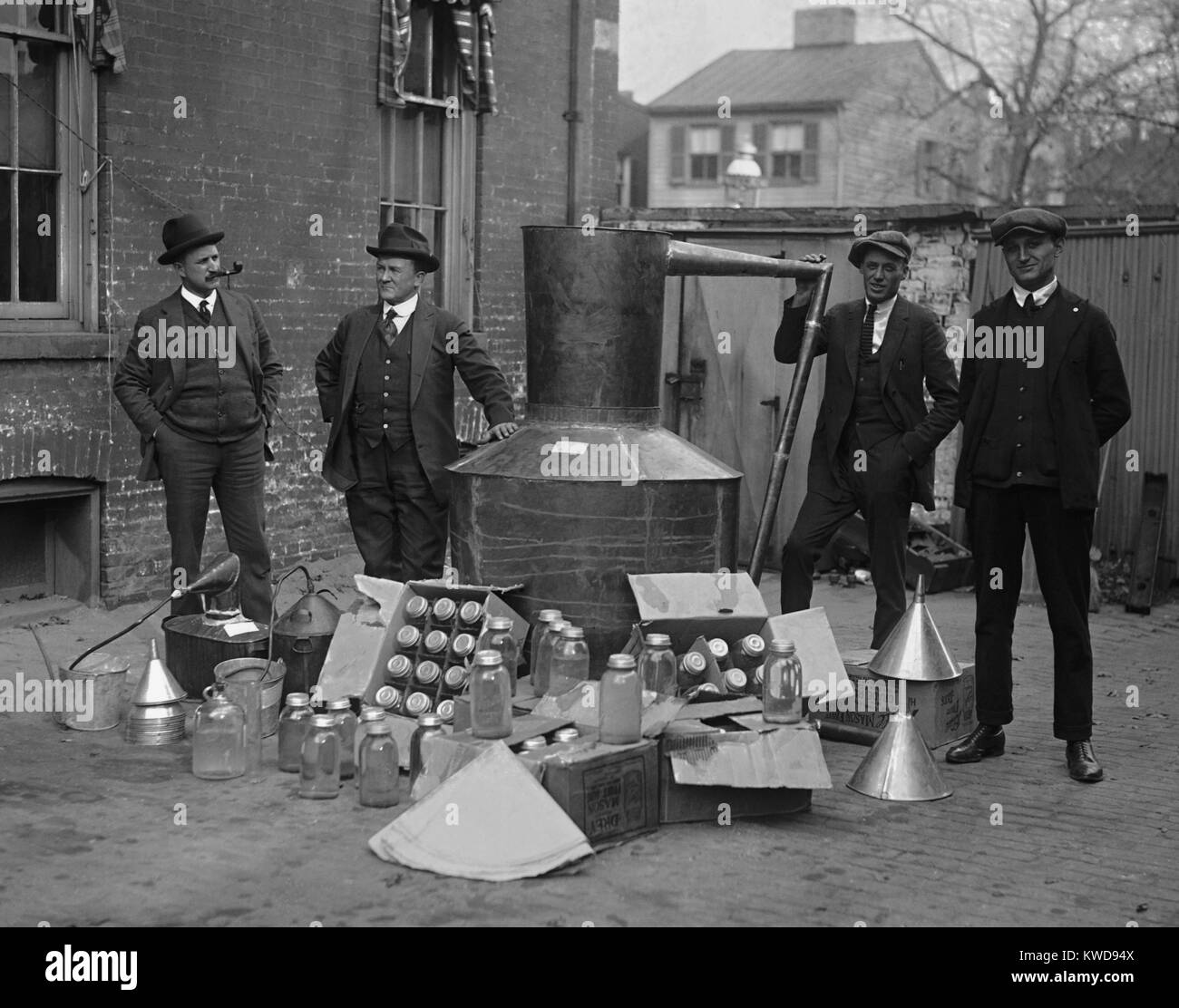 Gli agenti di divieto stand con una ancora e vasetti di vetro utilizzato per distillare liquori in Washington. Area D.C.. Nov. 11, 1922 (BSLOC 2016 8 70) Foto Stock