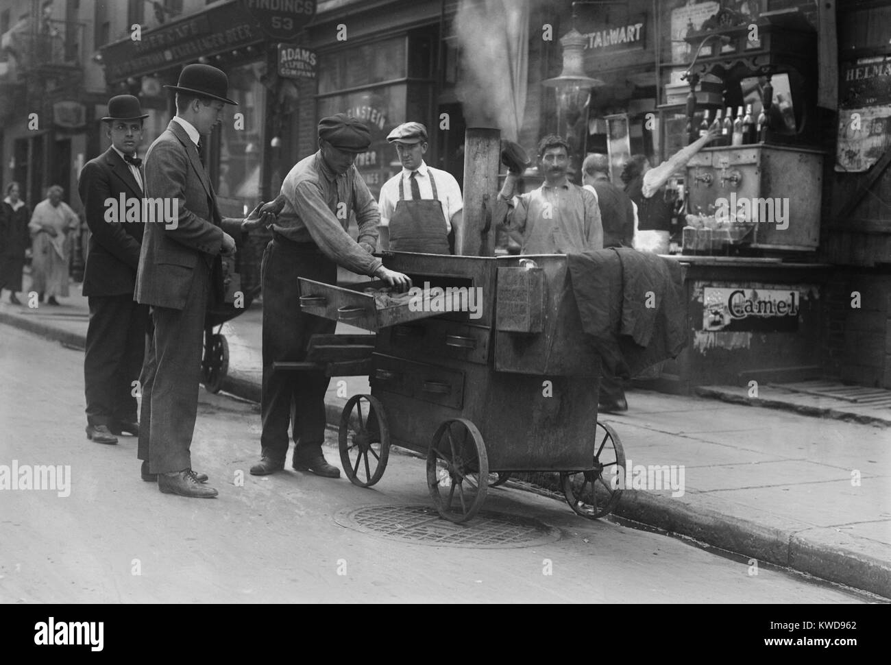 Patate al forno fornitore con un forno pushcart in New York del Lower East Side, c. 1915-20. Il quartiere è stato impaccato con Europeo Orientale immigrati ebrei (BSLOC 2016 8 81) Foto Stock