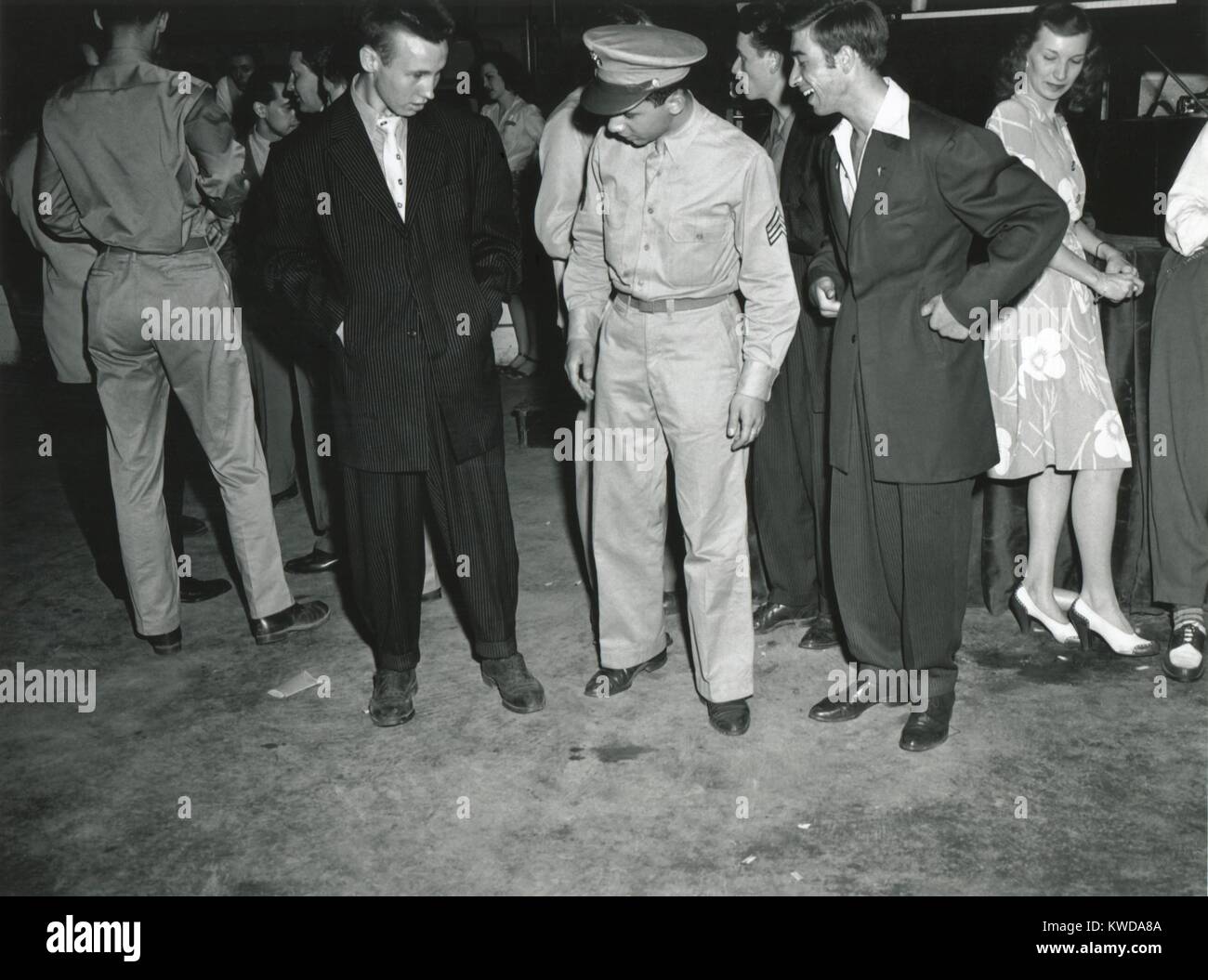 Soldato ispeziona Zoot Suiters presso un intermezzo di Woody Herman Orchestra di innesto. A Uline Arena, Washington D.C., Giugno 1942. Zoot sovradimensionato vestiti ostentati Guerra Mondiale 2 tessuto di razionamento, e più tardi perché come fonte di combattimenti di strada tra Zo (BSLOC 2016 7 9) Foto Stock