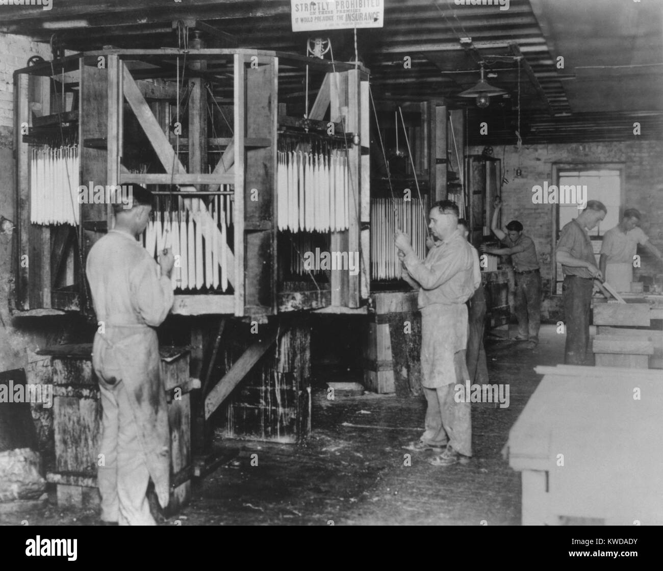 Workman mano candele di immersione presso il San Luigi candela e Wax Company, 1927. Creazione di candela è stato un settore in declino come gli americani hanno avuto accesso alle luci elettriche (BSLOC 2016 8 52) Foto Stock