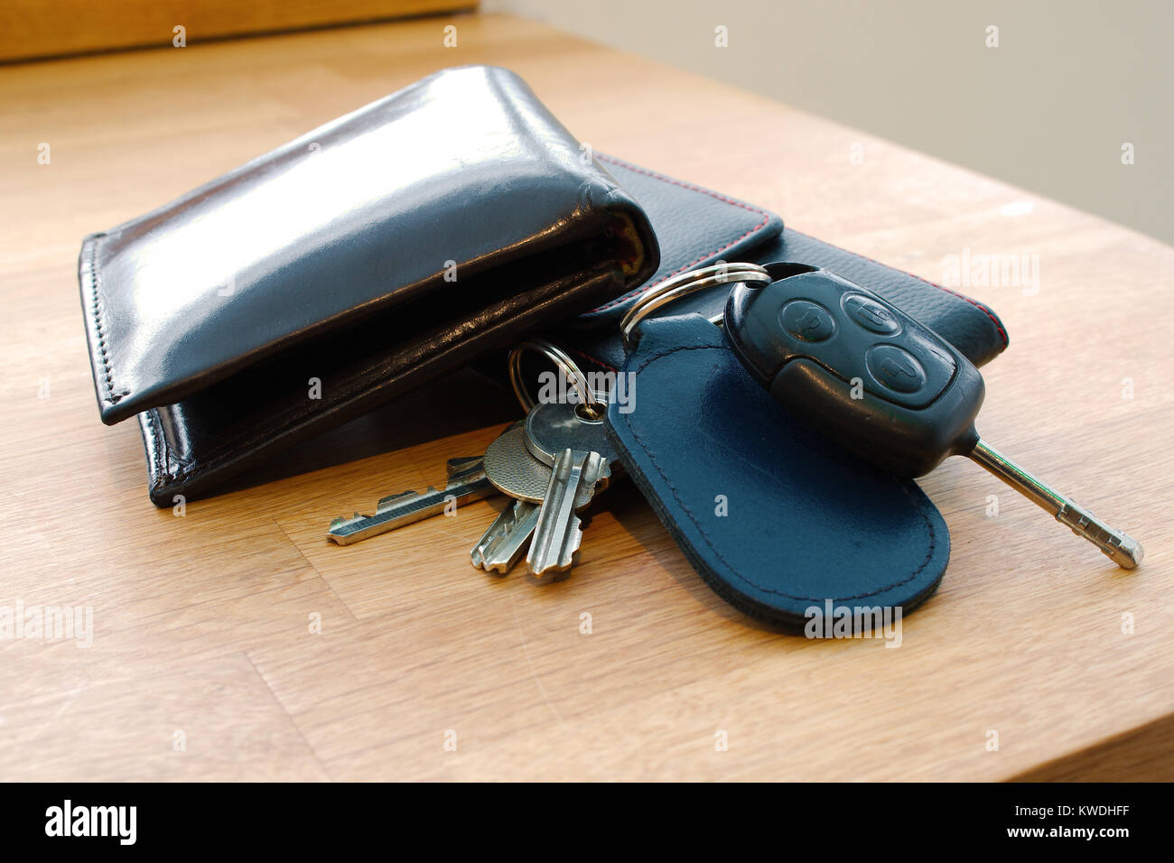 Portafogli, auto chiave, le chiavi di casa e il telefono cellulare su una  tabella insieme in modo tale che assomiglia a qualcuno è in procinto di  partire o appena arrivati Foto stock -