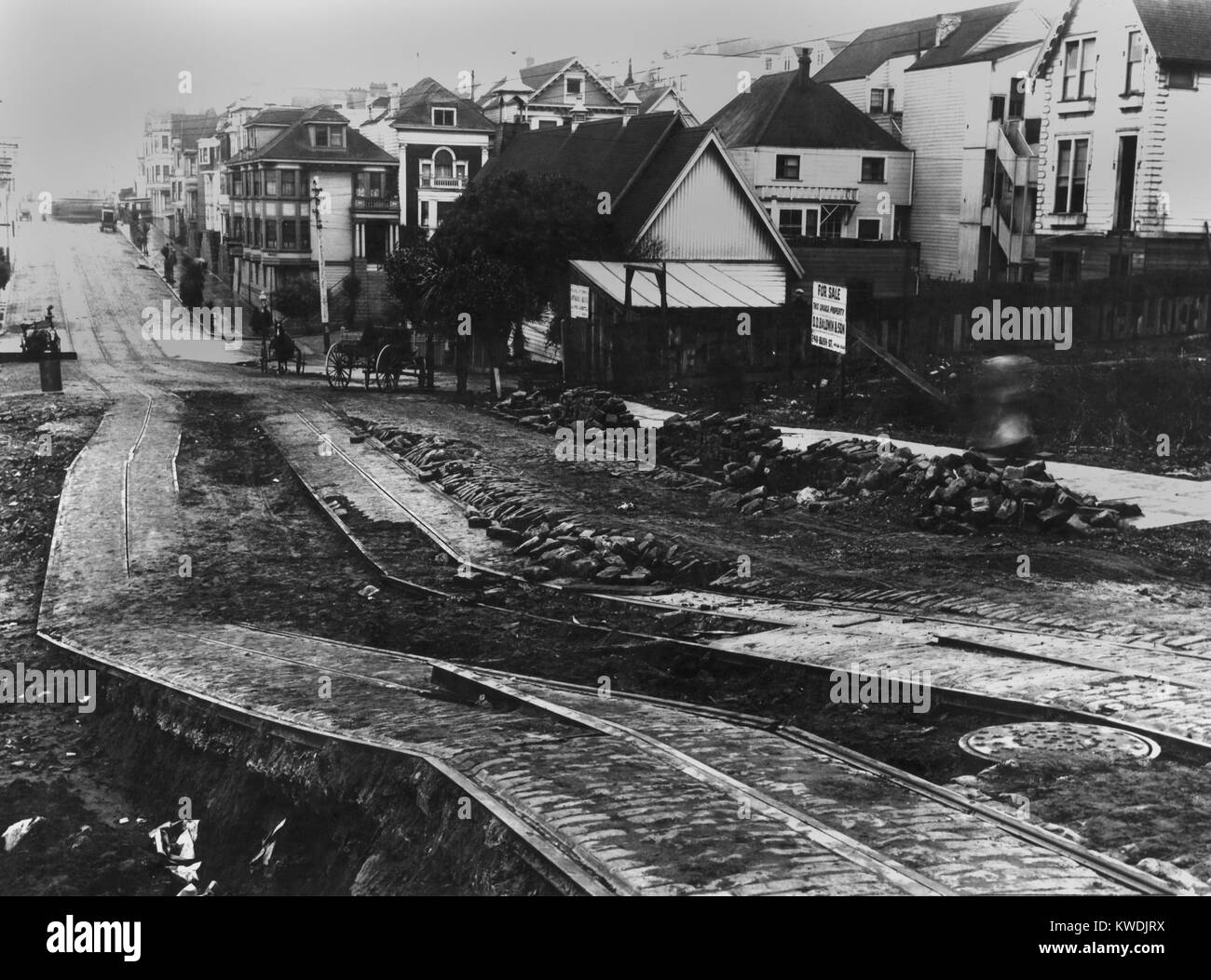 Danni alla strada di San Francisco auto brani dal San Francisco terremoto, 1906. La zona di primo piano è stato distorto dalla liquefazione del suolo, mentre i brani e gli edifici di distanza appaiono inalterate (BSLOC 2017 17 5) Foto Stock