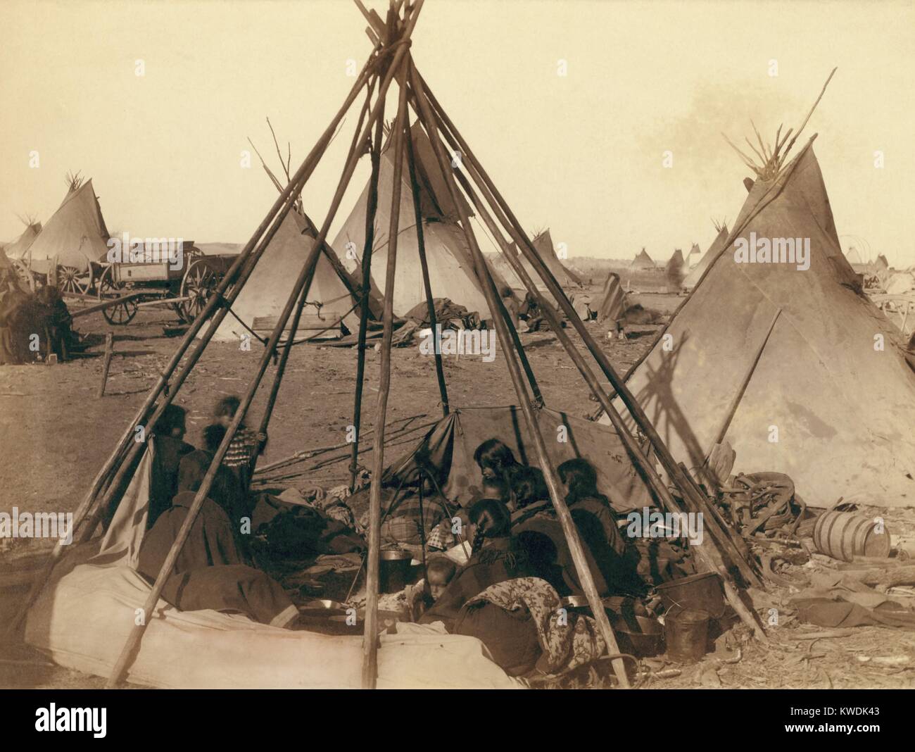 Oglala Sioux donne e bambini all'interno di una scoperta tende Tepee telaio vicino al Pine Ridge Agency, Gennaio 1891. Al di là di altri Indiani e i materiali entro il loro accampamento vicino al sito del Wounded Knee massacro. Foto di Giovanni Grabill, Gennaio 1891 (BSLOC 2017 18 33) Foto Stock