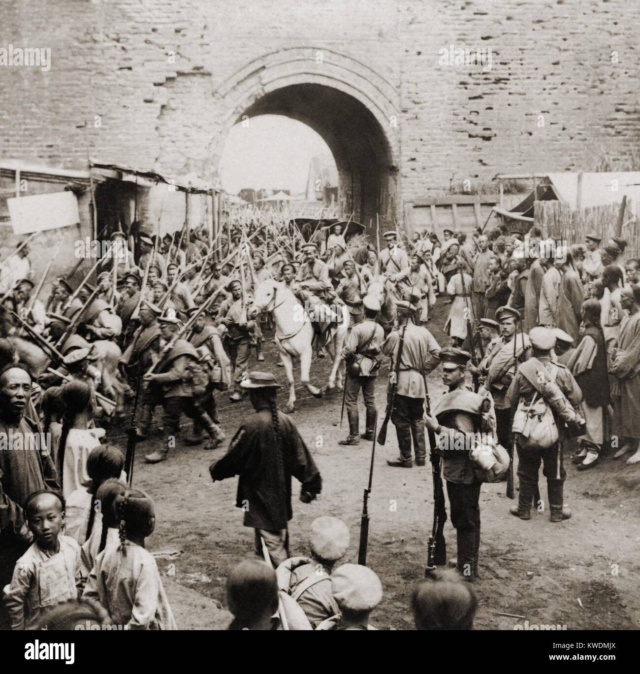 Soldati russi che passa attraverso le porte di Mukden, Manciuria, durante la guerra Russo-Giapponese, possibilmente in febbraio 1905. Questi possono essere nuove truppe, rinforzi per l'esercito comandato dal generale Aleksei Nikolaevich Kuropatkin. Cinese di uomini, donne e bambini, i residenti della città, guarda le truppe. Le forze giapponesi occuparono Mukden nel marzo 1905, costringendo il russo ritiro armys Chinese-Russian frontiera (BSLOC 2017 18 114) Foto Stock