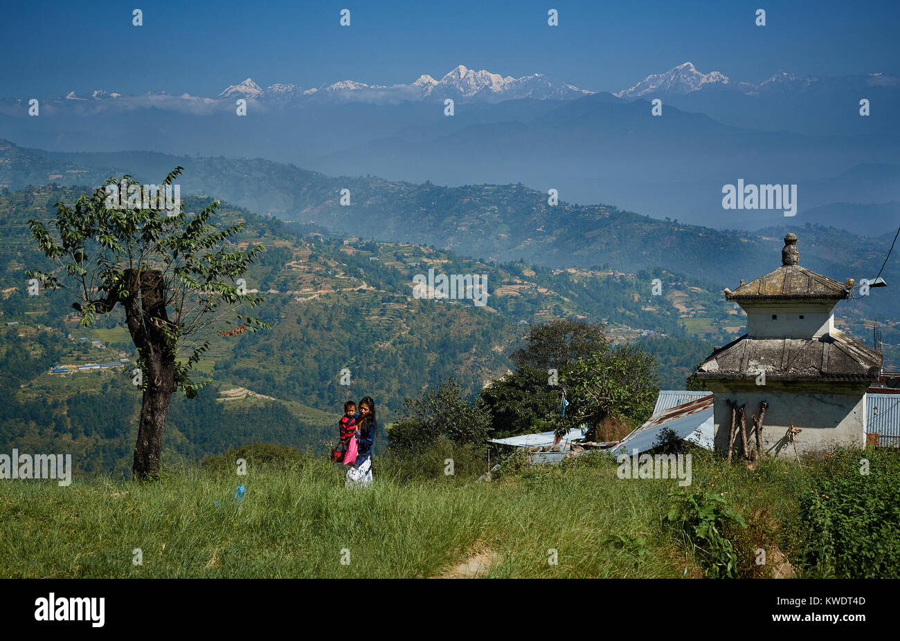 Ragazza Newari bambino portando nella parte anteriore del Himalaya gamma, Dulikhel, Valle di Katmandu, Nepal Foto Stock