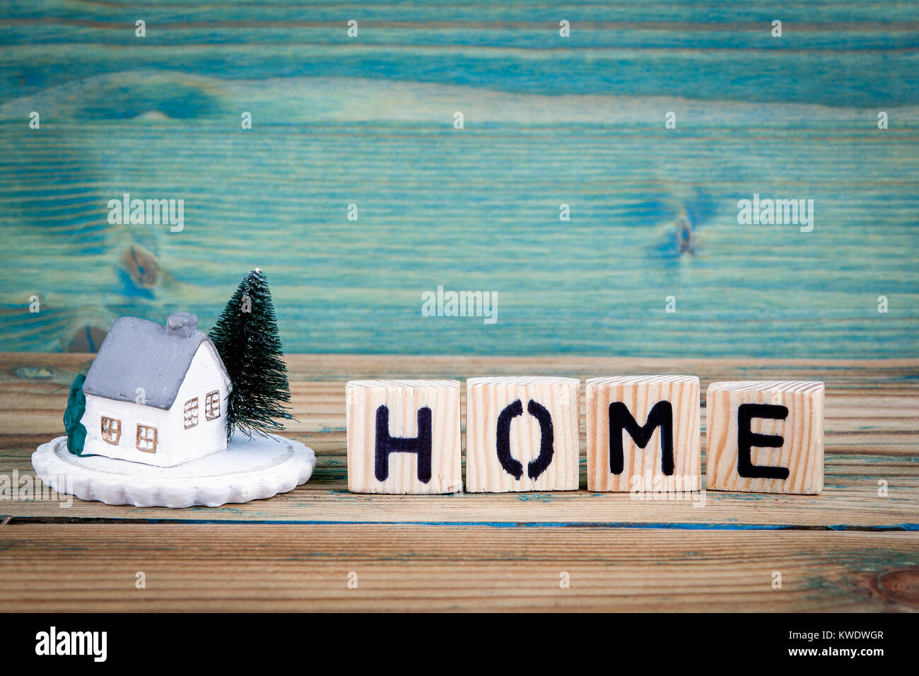 Modello in miniatura della casa di legno e testo lettera: home. Foto Stock
