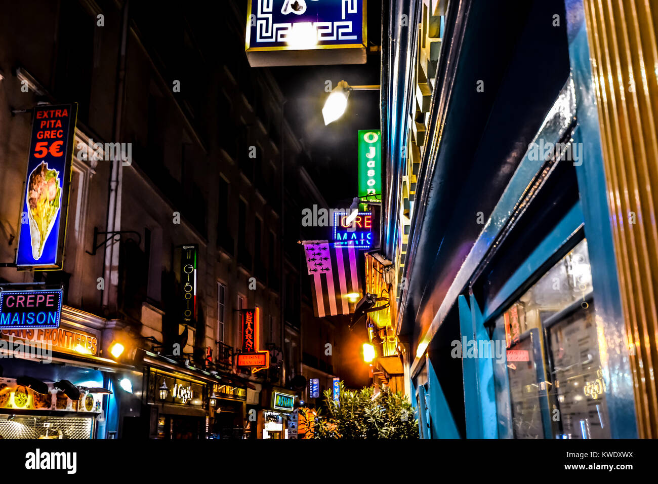 A tarda notte nel Quartiere Latino di Parigi Francia con coloratissime insegne al neon e luci con una varietà di caffè e ristoranti Foto Stock