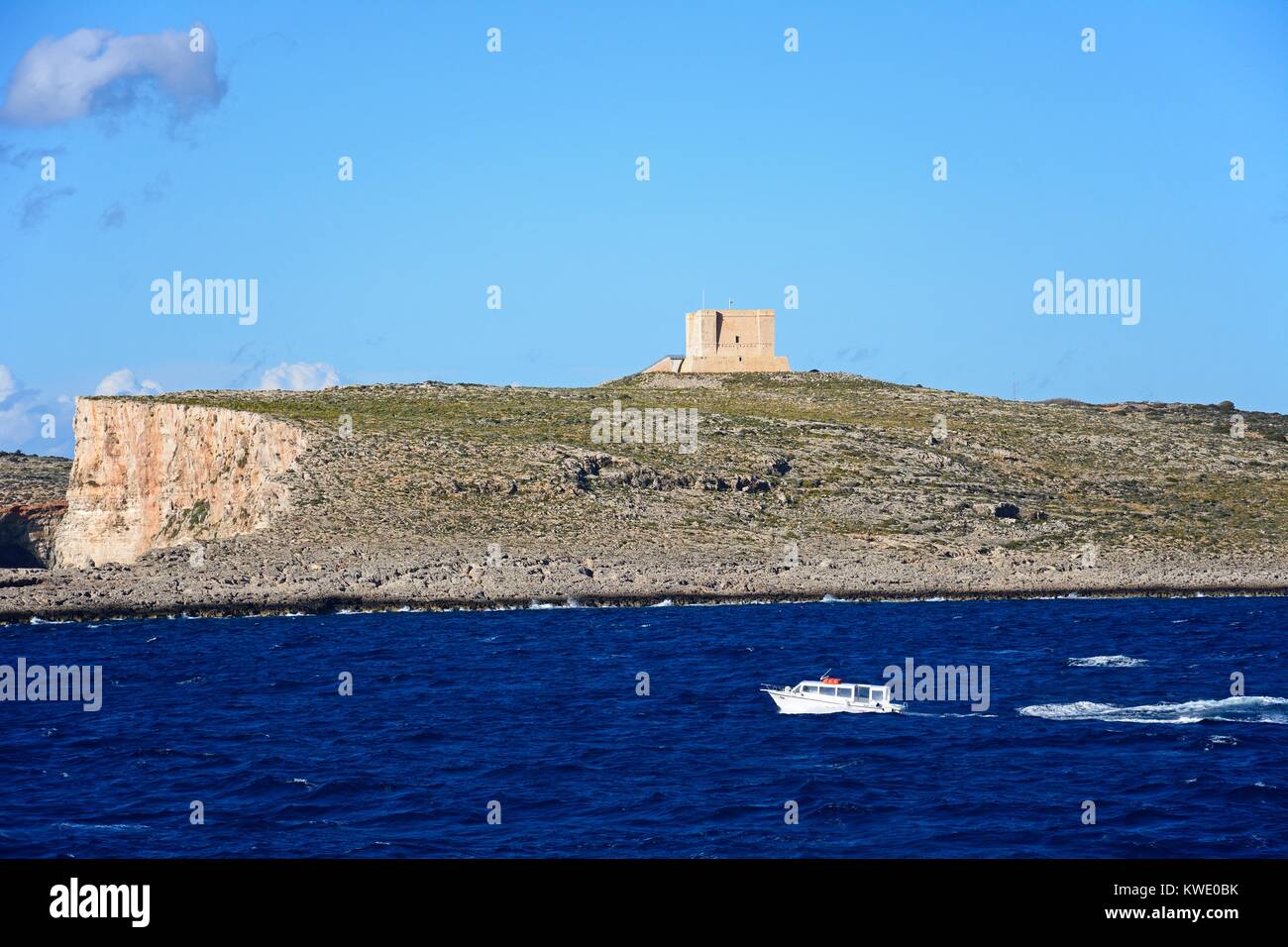 Vista dell'isola con una piccola barca in primo piano durante la primavera, Comino, Malta, l'Europa. Foto Stock